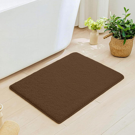 Brown bathmat on light bathroom floor near bathtub and indoor plants