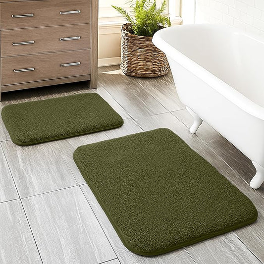 Set of two olive green bathmats on modern bathroom tile by bathtub and cabinet