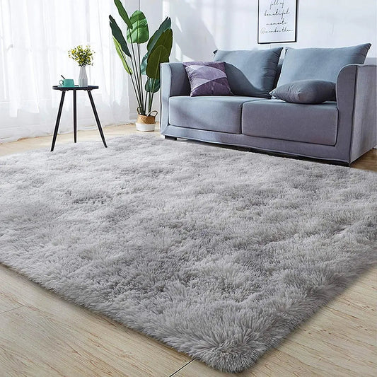 Gray shaggy area rug in modern living room with sofa, table, and indoor plant