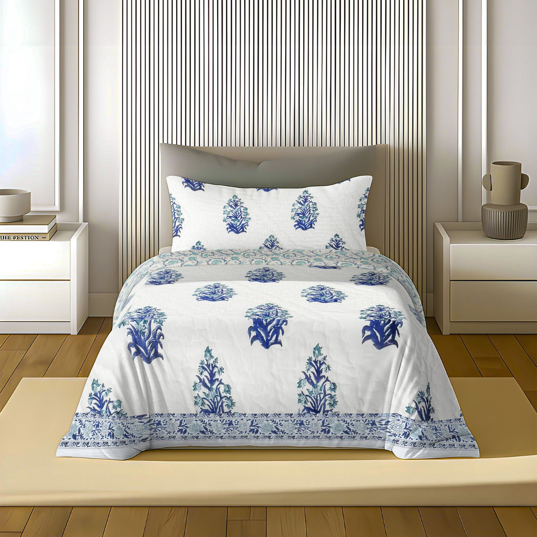 Blue and white floral quilt set on bed in modern bedroom with wooden floor and nightstands