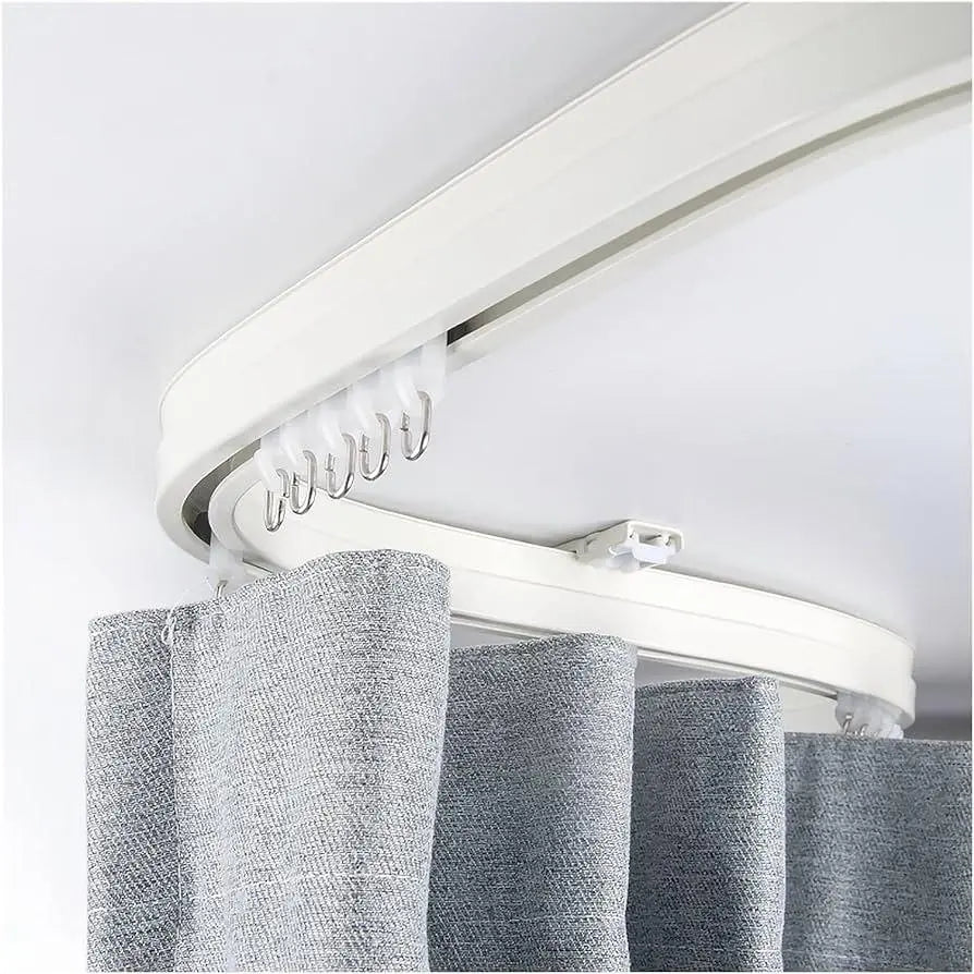 Curved ceiling curtain track with light grey fabric curtain hanging on hooks