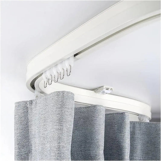 Curved ceiling curtain track with light grey fabric curtain hanging on hooks