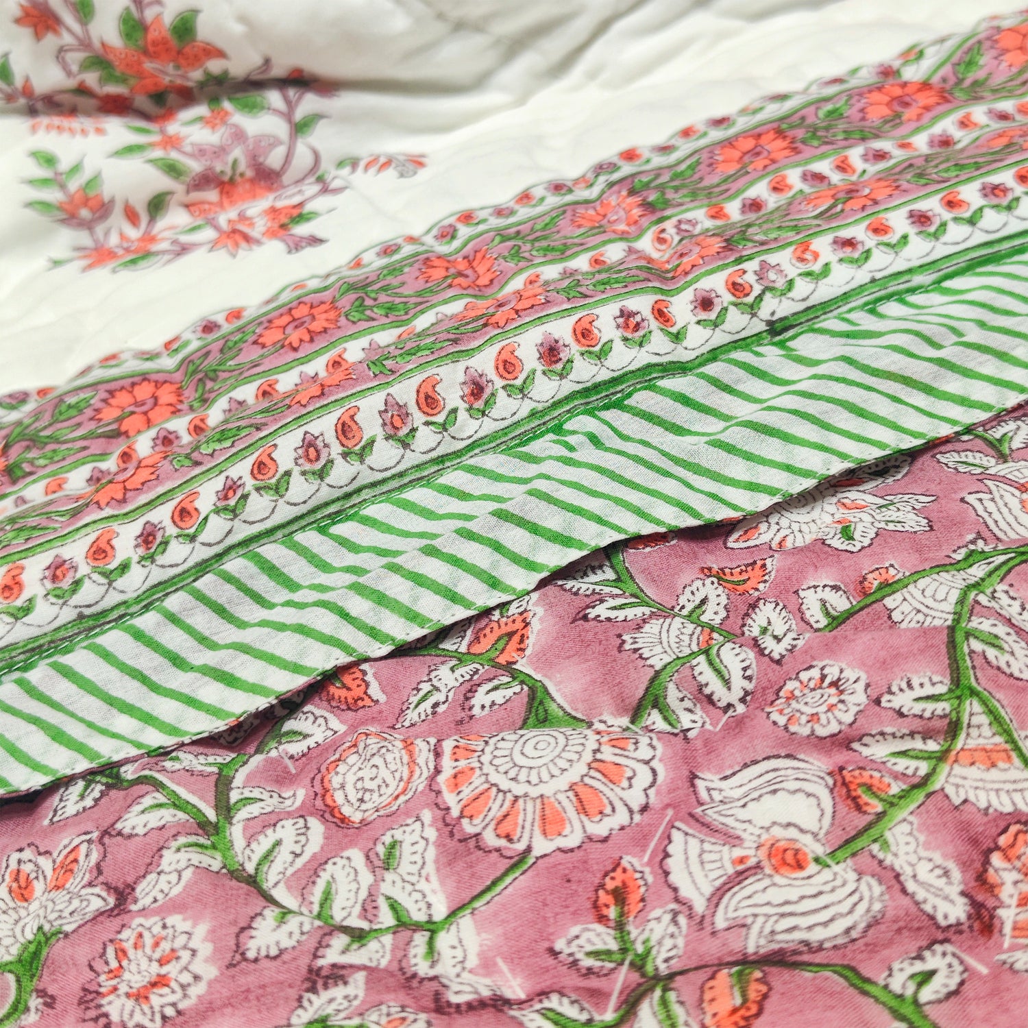 Lavender quilt with floral patterns, green stripes, and intricate printed border