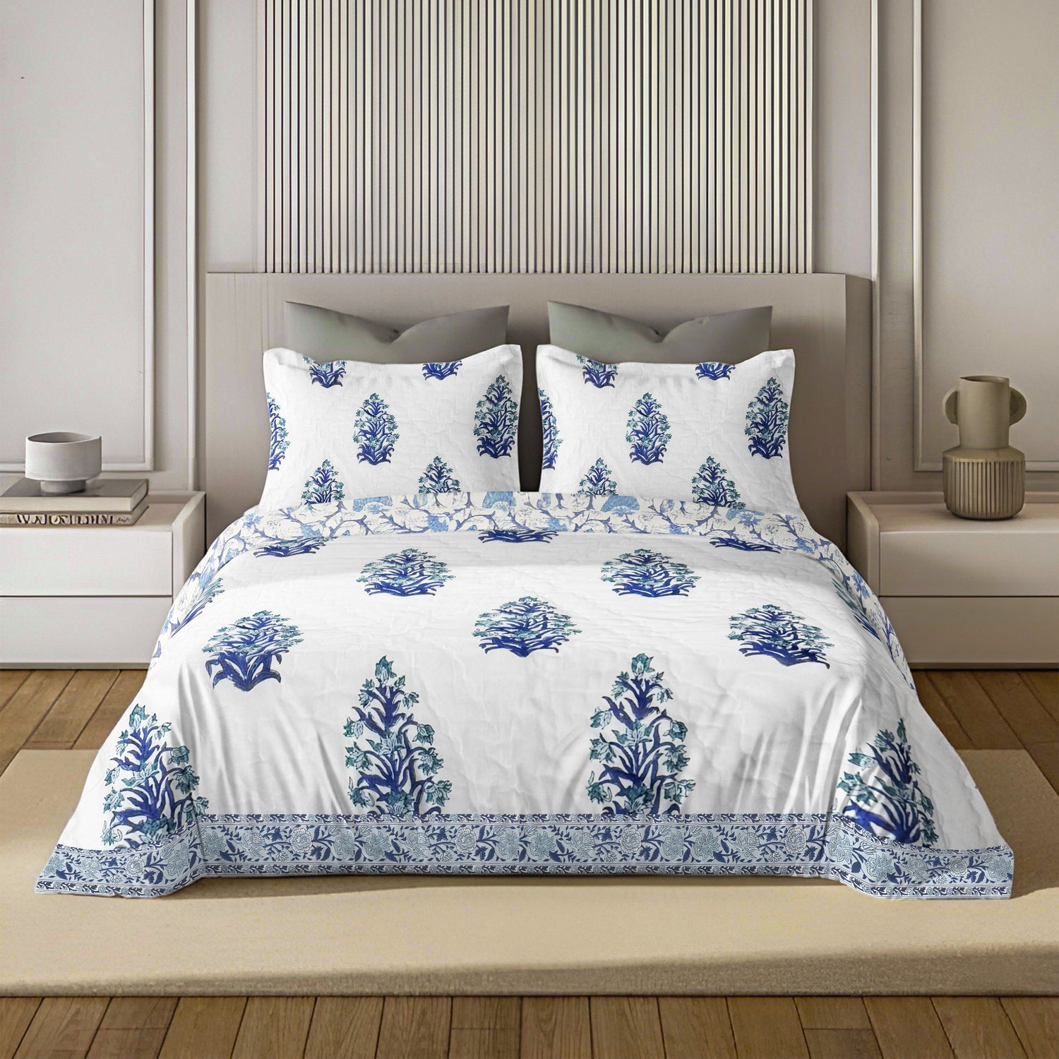 White quilt with blue floral print and matching pillow covers on a modern bed