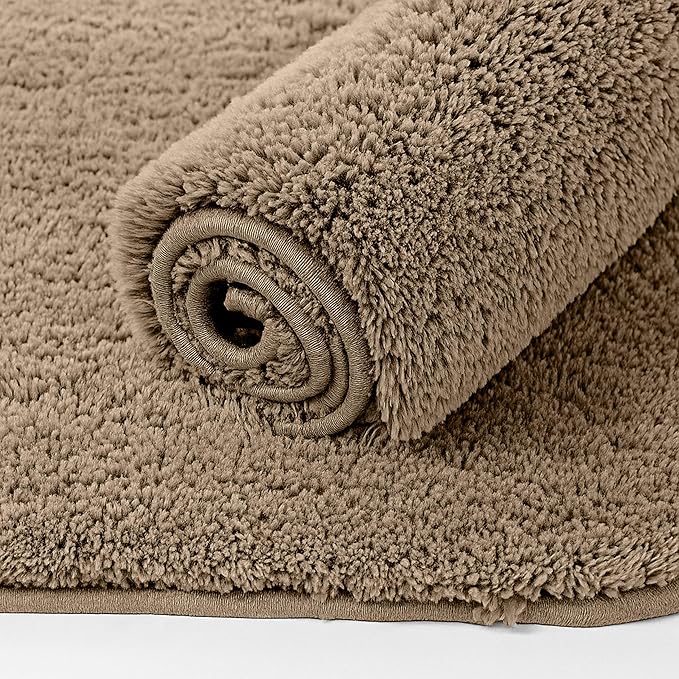 Rolled beige bathmat with soft, plush texture on a matching background