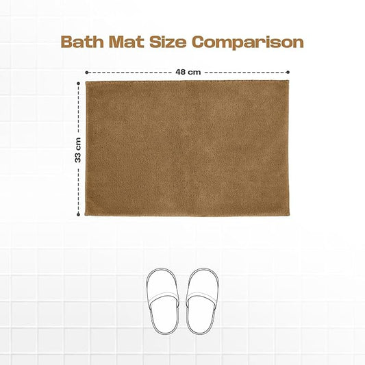 Brown rectangular bath mat size 48x33 cm on white tile, with slippers for scale.