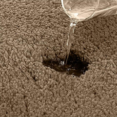 Water being poured onto an absorbent brown bathmat surface showing high absorbency