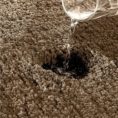 Water being poured onto a thick, absorbent bathmat to show water absorption