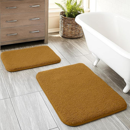Soft brown bathmats on tiled bathroom floor near bathtub and cabinet