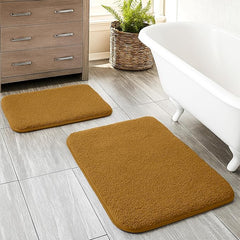Soft brown bathmats on tiled bathroom floor near bathtub and cabinet