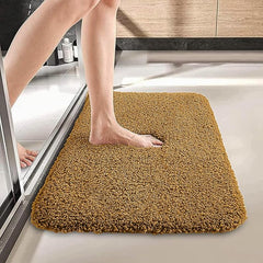 Foot stepping onto a soft brown bathmat in a modern bathroom setting
