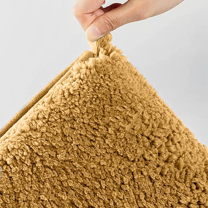Hand holding a soft textured brown pillow with plush fabric