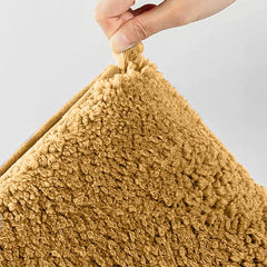 Hand holding a soft textured brown pillow with plush fabric