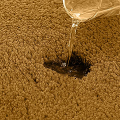 Water being poured onto a brown absorbent bathmat, showing its water absorption feature