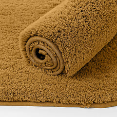 Soft brown bathmat rolled up on a flat surface, fluffy texture, home bathroom decor.