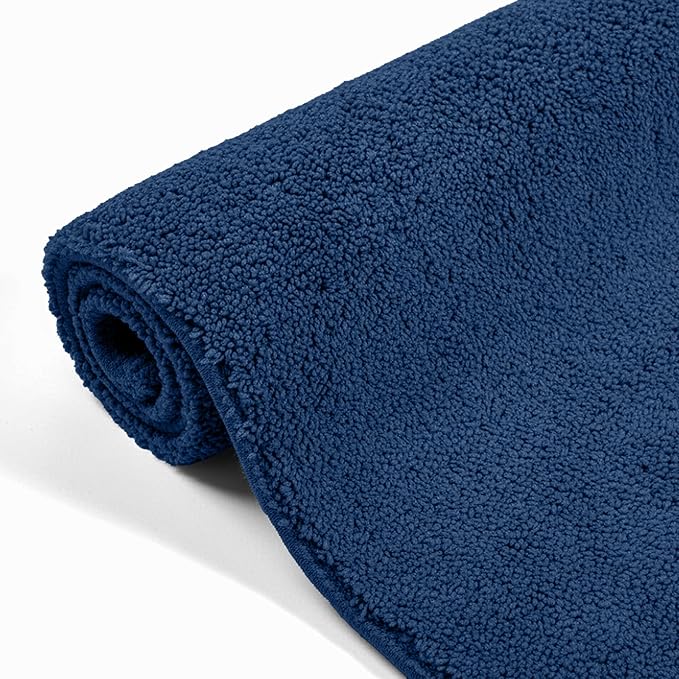 Rolled navy blue bathmat with textured, absorbent surface on white background