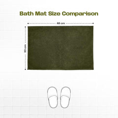 Olive green bath mat size comparison 48x33 cm with slippers on tile floor background