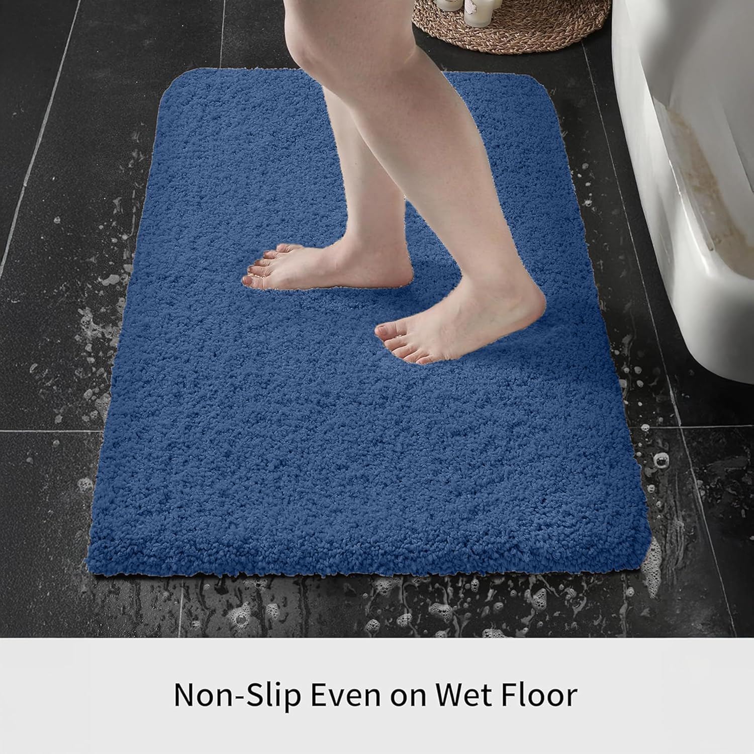 Blue non-slip bathmat on wet bathroom floor with bare feet stepping on it