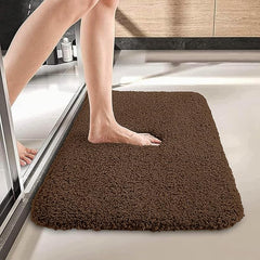 Brown bathmat with foot stepping out of shower on soft absorbent bathroom floor mat