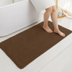 Brown bathmat on bathroom floor with person stepping out of bathtub