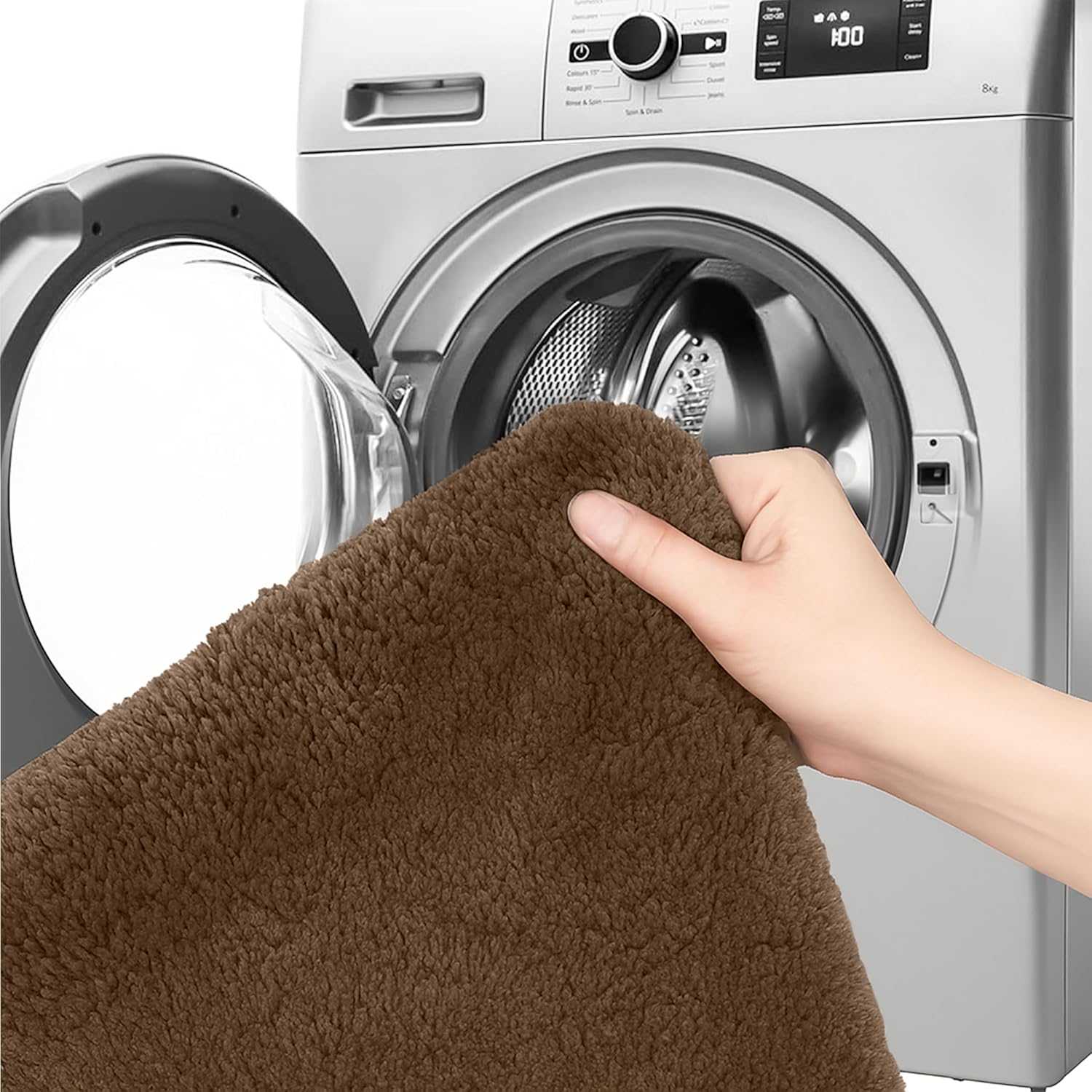Hand holding brown bathmat in front of washing machine, showing washable bathroom rug