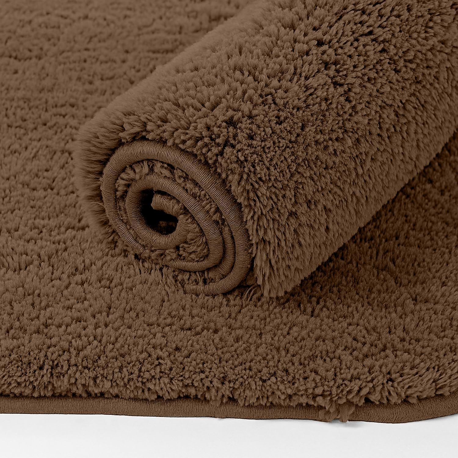 Brown fluffy bathmat rolled up, soft bathroom mat with textured surface