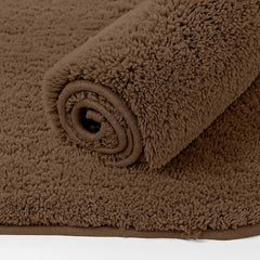 Brown fluffy bathmat rolled up, soft bathroom mat with textured surface