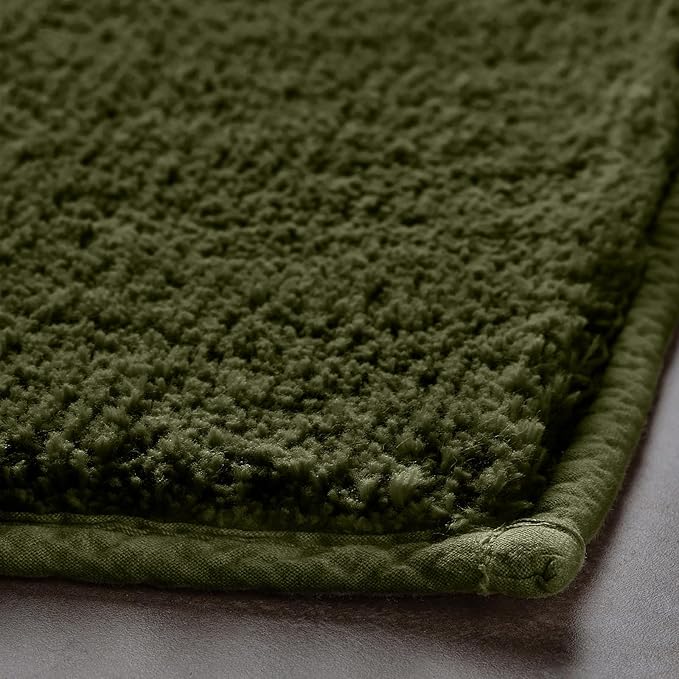 Close-up of a green textured bathmat with soft, plush fibers on a bathroom floor