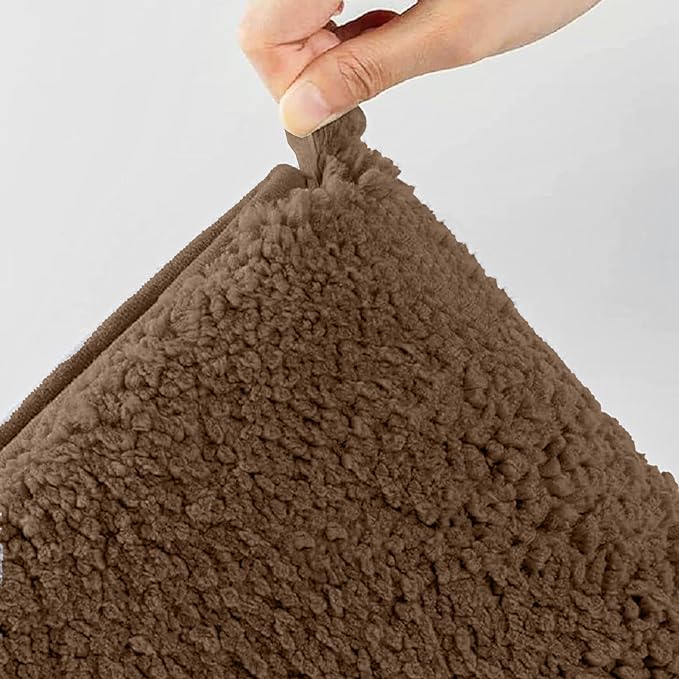 Hand holding a soft brown sherpa bathmat with a textured surface