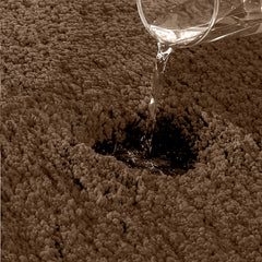 Water being poured onto an absorbent, textured bathmat surface