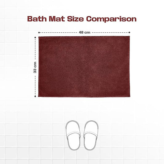 Maroon bath mat size 48x33 cm with slipper outline for size comparison on tiled floor