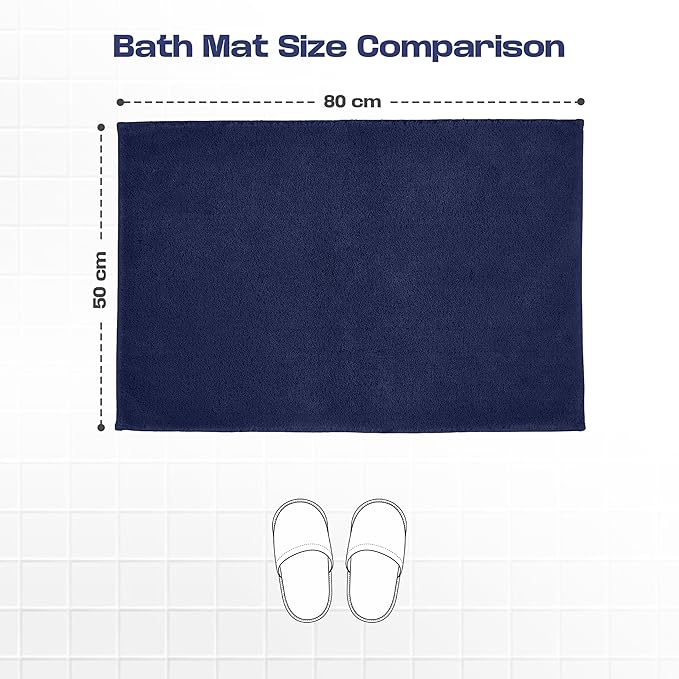 Navy blue bath mat 50x80 cm with slippers for size comparison on white tile floor