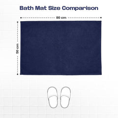Navy blue bath mat 50x80 cm with slippers for size comparison on white tile floor