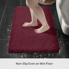 Person stepping on a non-slip burgundy bathmat on wet bathroom floor next to bathtub