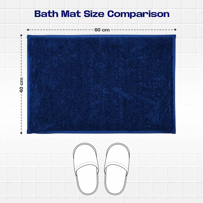 Navy blue rectangular bath mat size 60x40 cm on tiled floor with slippers for scale.