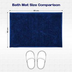 Navy blue rectangular bath mat size 60x40 cm on tiled floor with slippers for scale.