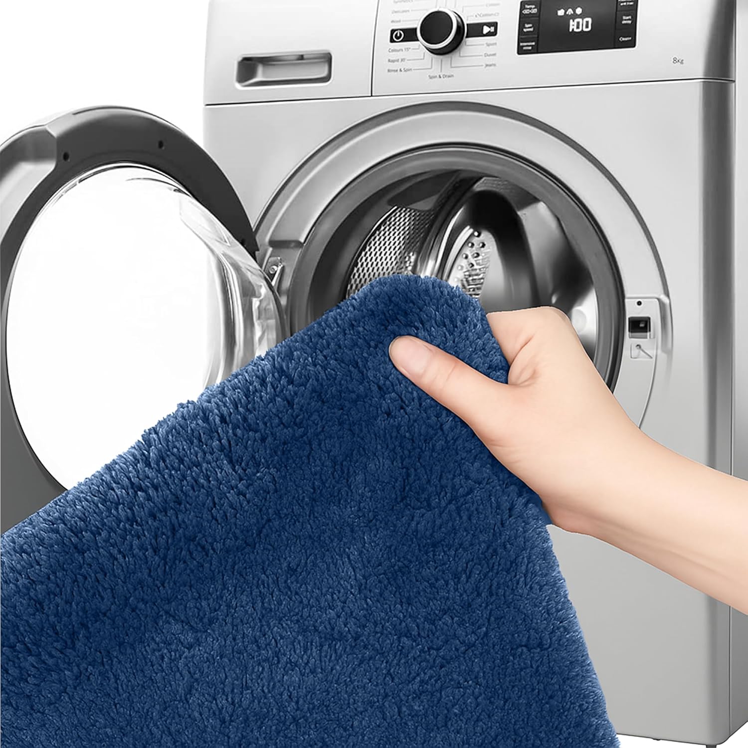 Hand holding soft blue bathmat in front of washing machine, washable bathroom rug