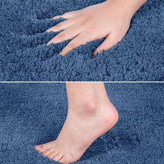 Hand and bare foot touching a soft blue bathroom mat with plush texture