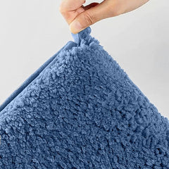 Hand holding a soft blue sherpa pillow with plush textured surface