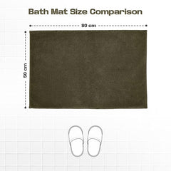 Dark brown rectangular bath mat 50x80 cm on white tile floor with slippers for size comparison