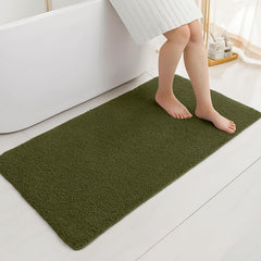 Soft green bathmat on white bathroom floor beside a bathtub with a person standing