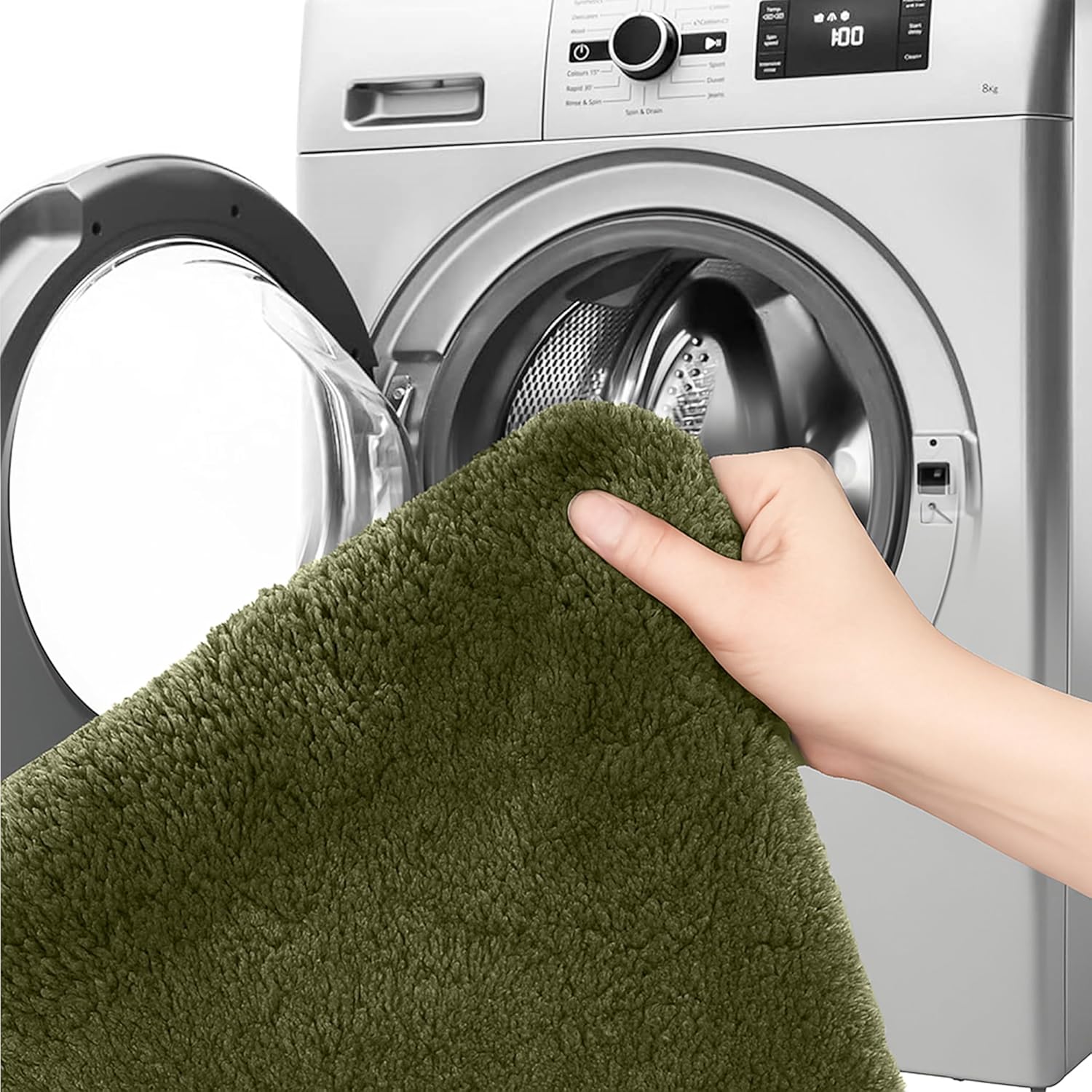 Hand holding a green fluffy bathmat near a front-loading washing machine