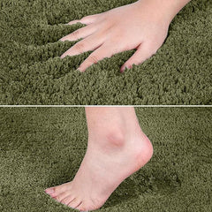 Hand and foot pressing on soft green bathmat, showing plush texture and comfort