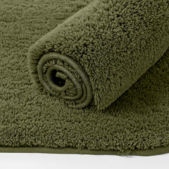 Rolled olive green bathmat with soft, plush texture, ideal for bathroom decor