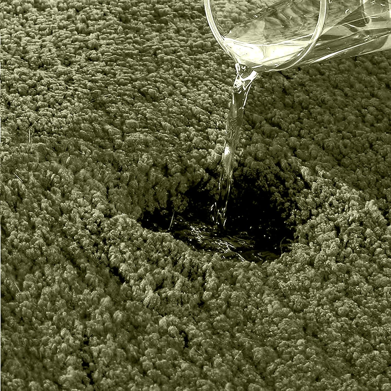 Water being poured onto absorbent bathmat surface, demonstrating liquid absorption