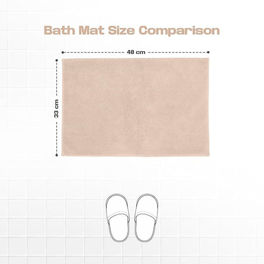 Beige bath mat with 48x33 cm size comparison on white tile background, slippers illustration below
