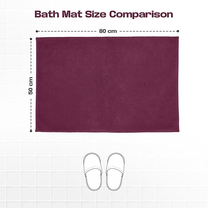 Plum bath mat 50x80 cm displayed on white tile floor with slippers and size comparison chart.