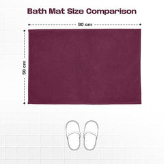 Plum bath mat 50x80 cm displayed on white tile floor with slippers and size comparison chart.