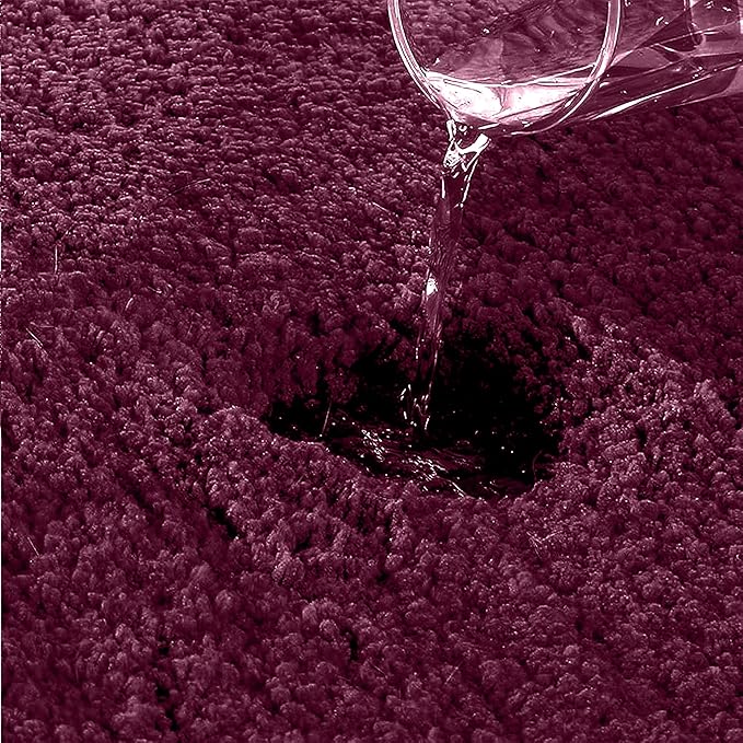 Water being poured on a dark purple absorbent bathmat showing high absorbency.