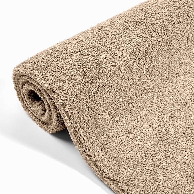 Beige rolled terry bathmat with soft, textured surface on a white background